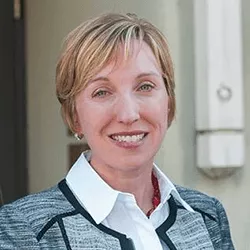 Dr. Margaret A. Roth wearing a white dress shirt under a gray and black sweater