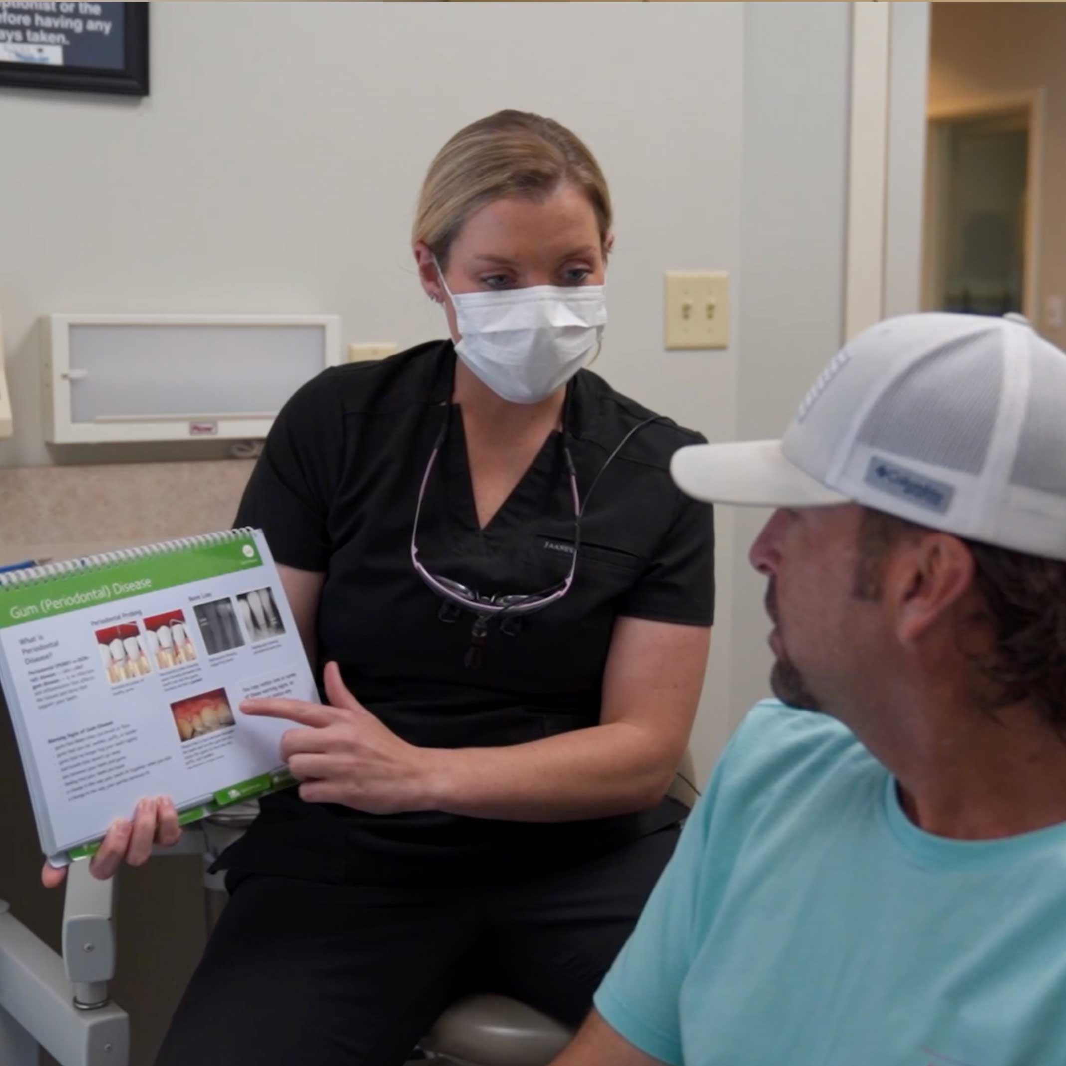 A dental assistant at Rocky Creek Dental Care in Greer, SC shows a tooth graphic and information to a patient at Rocky Creek Dental Care