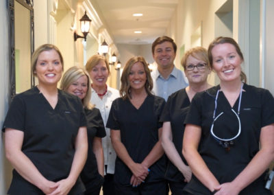 The dental team of Rocky Creek Dental Care standing together in the hallway of their building