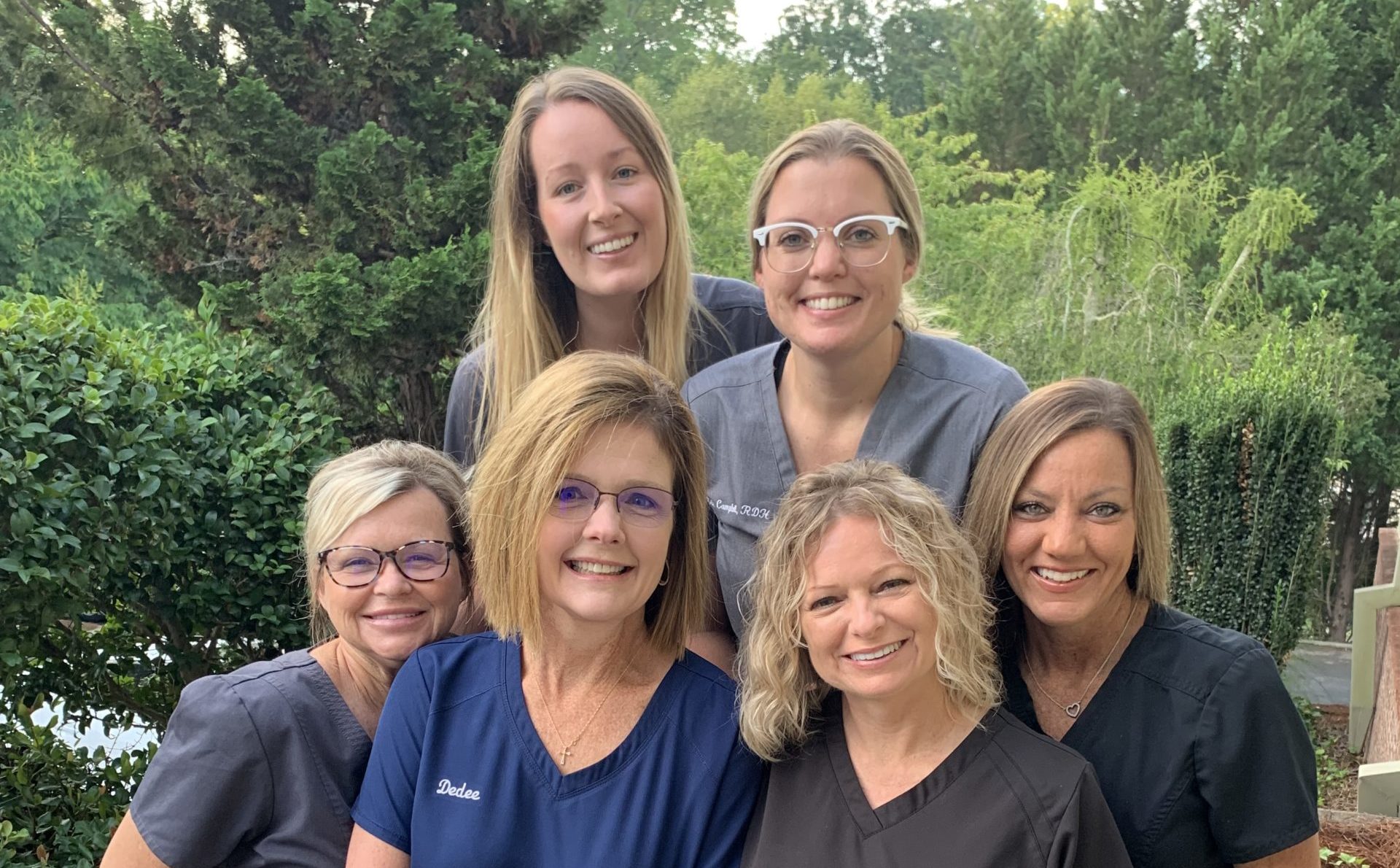 Cleveland Park Staff posing together on a porch at Rocky Creek Dental Care in Greeneville, SC