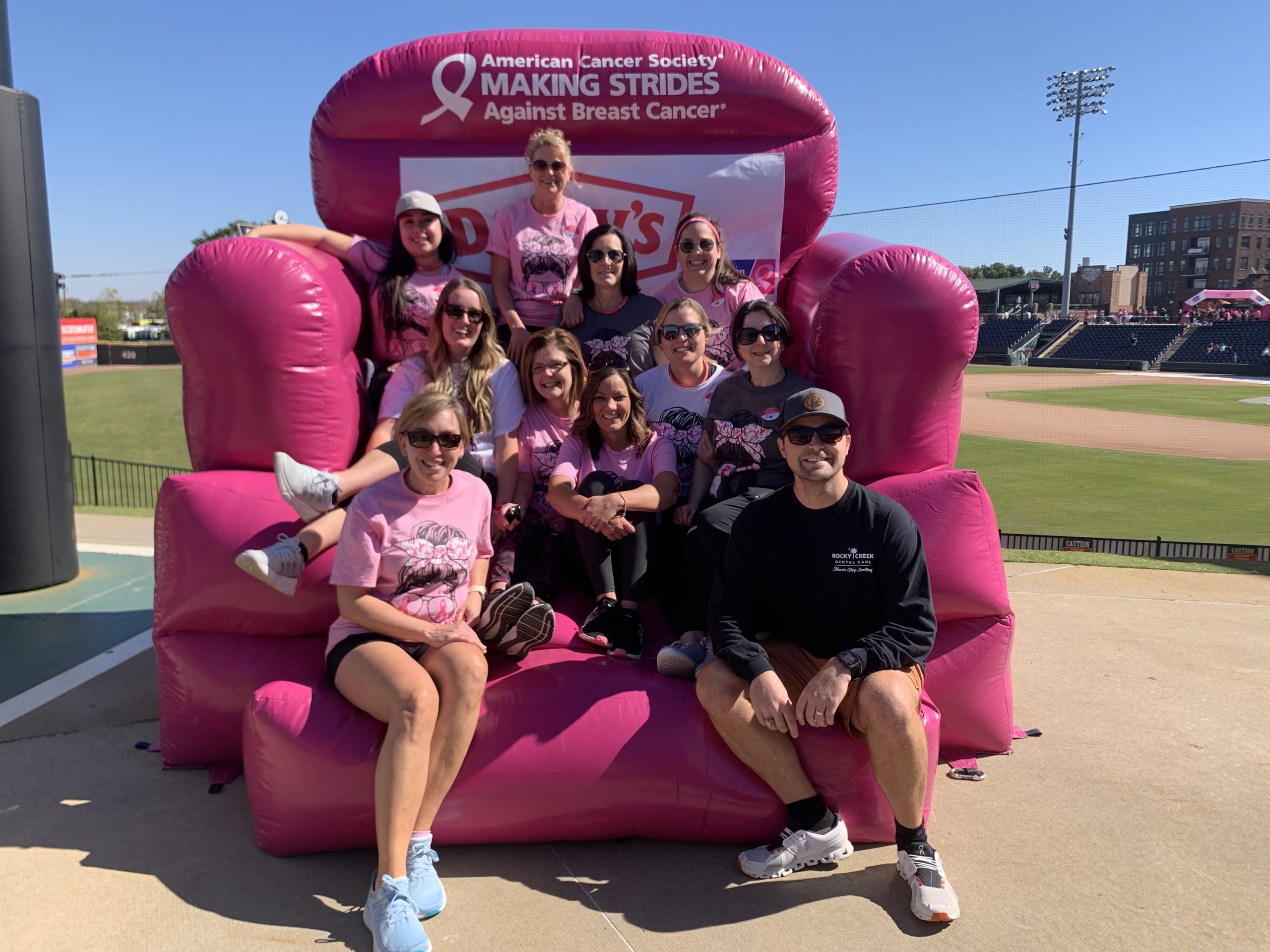 The entire dental staff of Rocky Creek Dental Care sitting on top of an inflatable chair from The American Cancer Society